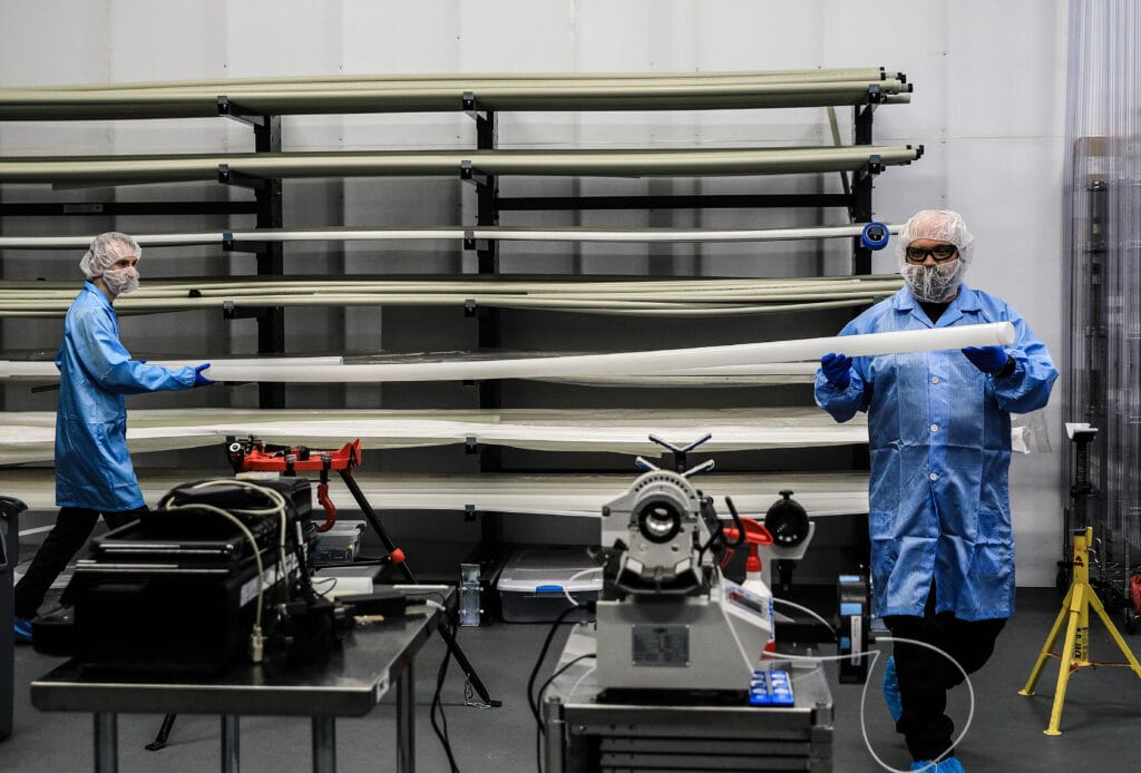 Workers in safety gear working with plastic piping